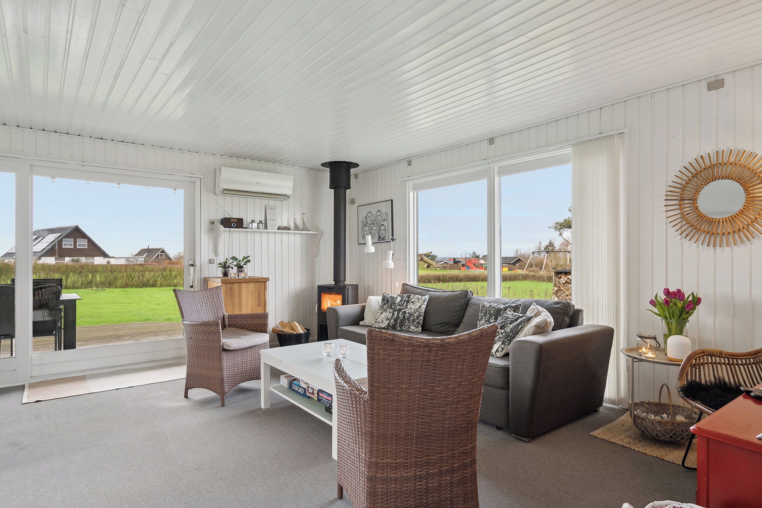 A spacious living area with a sofa, chairs, a coffee table, and a fireplace.