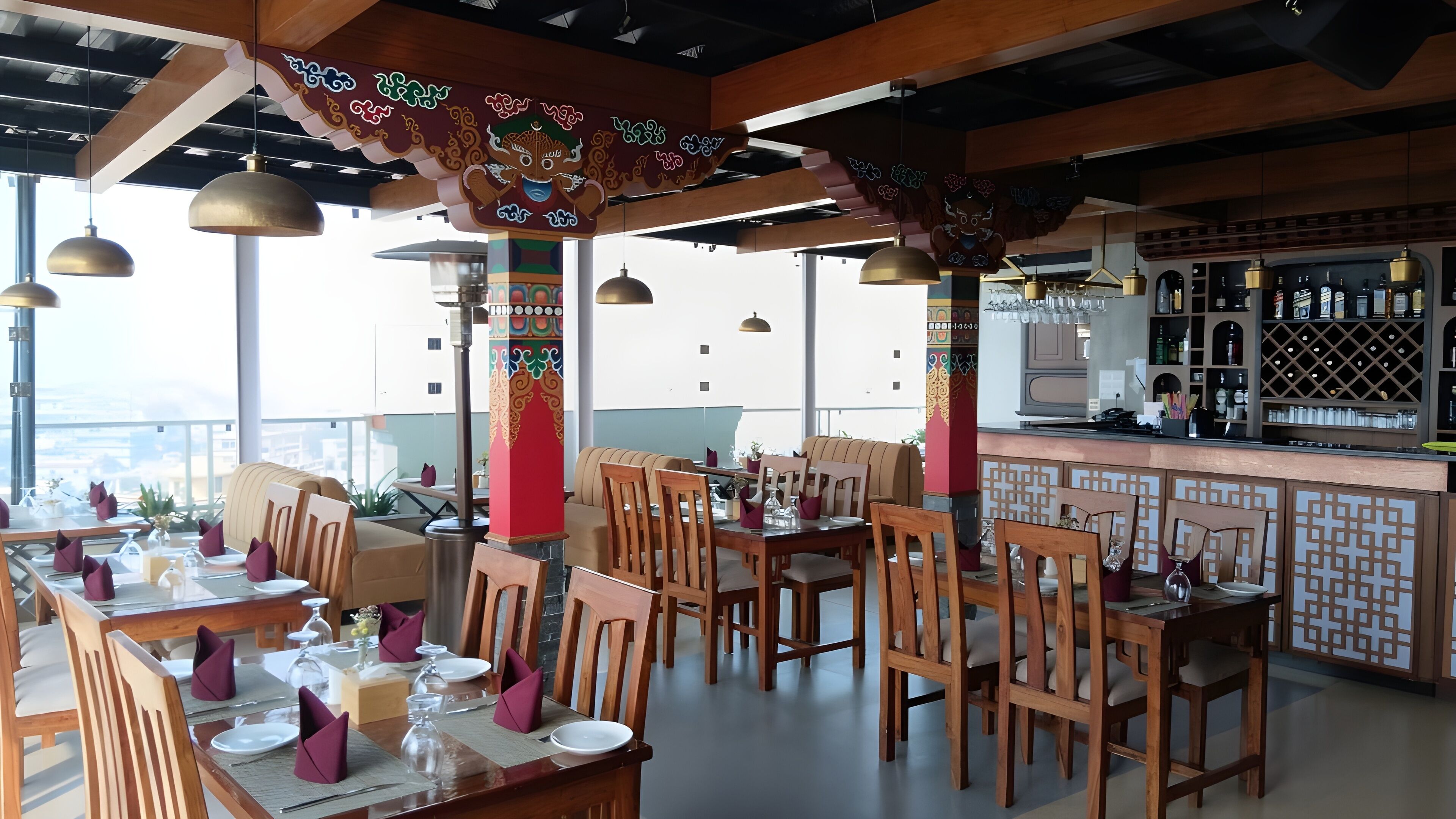 A restaurant with wooden furniture, a bar area, and a view of the city.