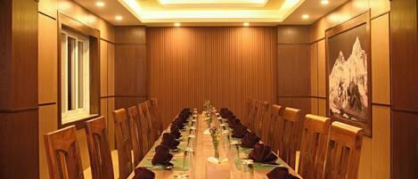 A conference room with a long table, chairs, and a ceiling light.