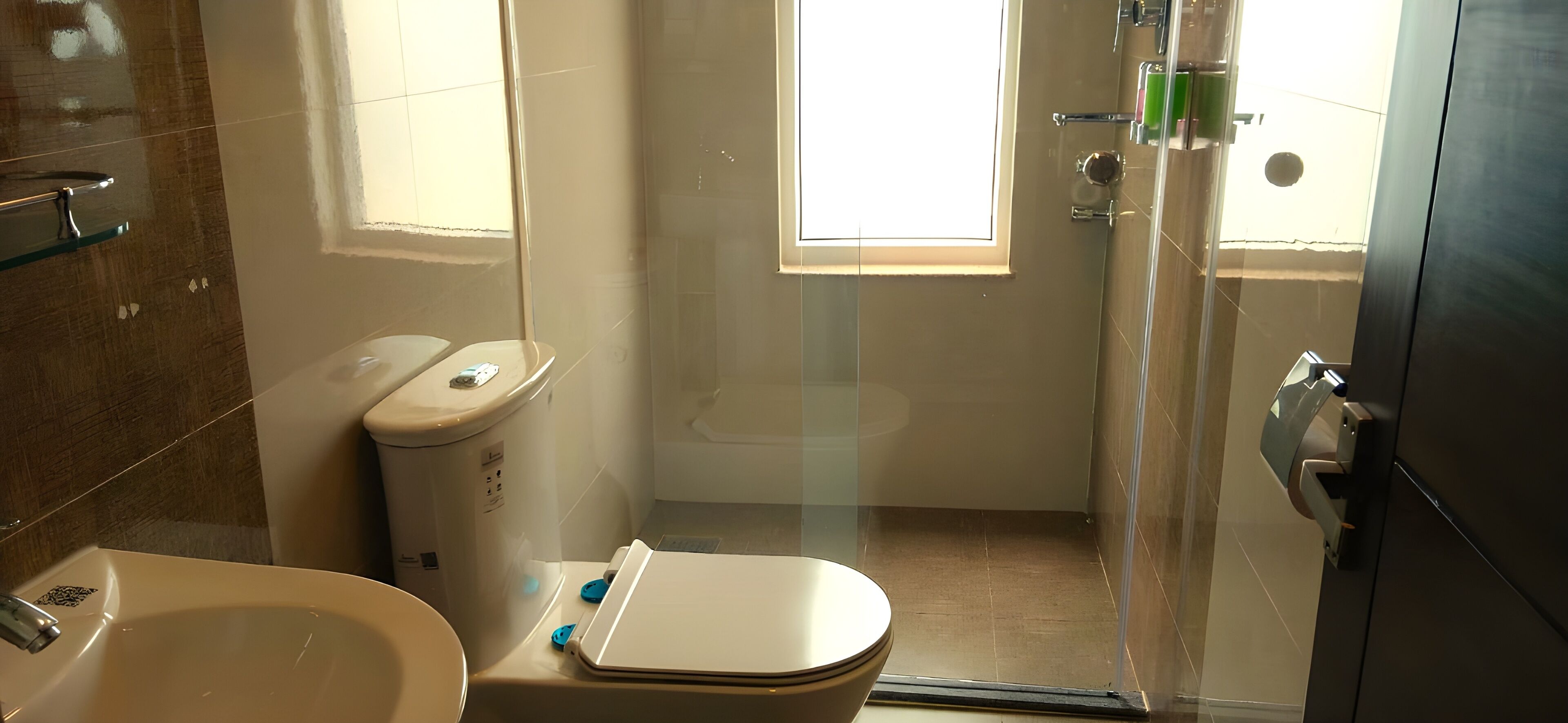 A bathroom with a toilet, sink, and shower area.