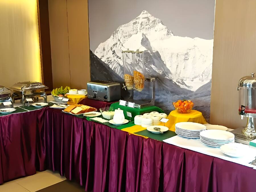 A buffet setup with various food items and a mountain view backdrop.