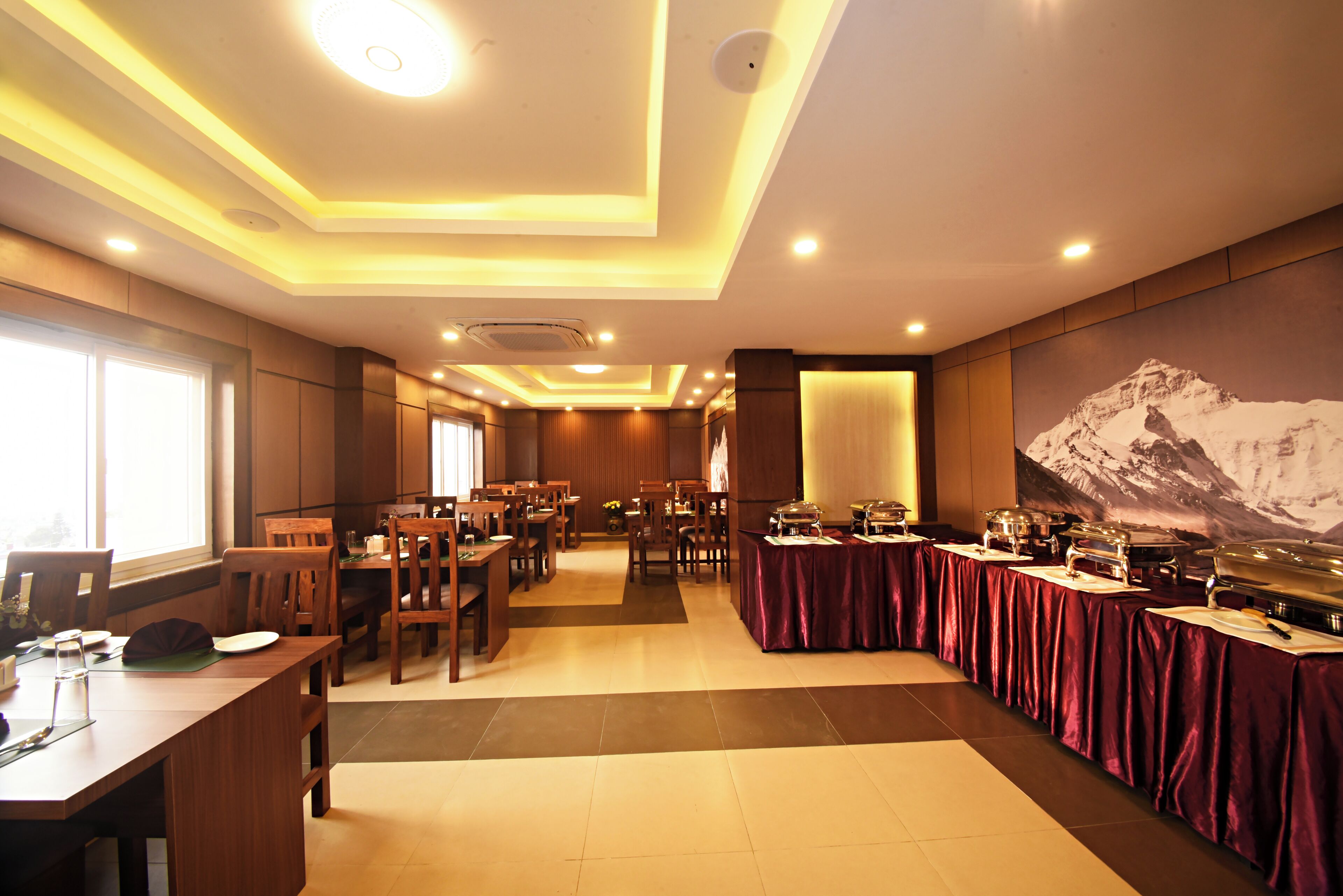 A dining area with multiple tables, chairs, and a buffet setup.