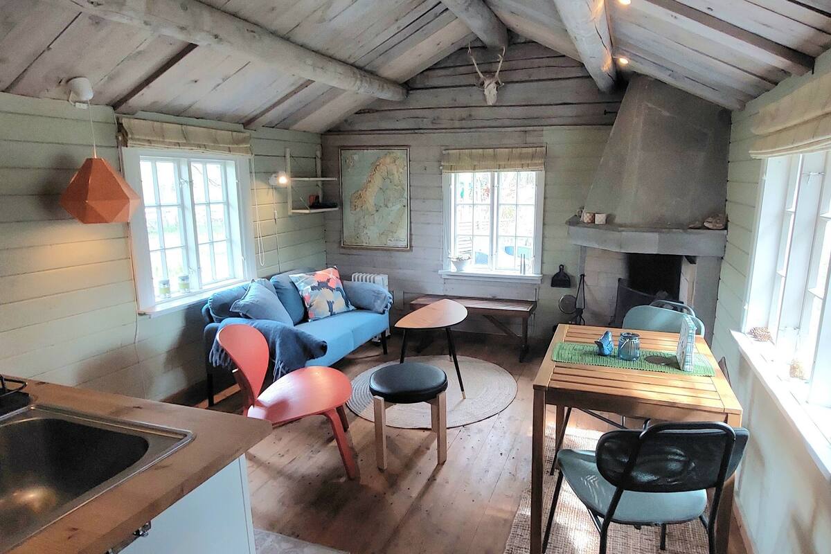 A rustic cabin interior with a kitchen, dining area, and living space.