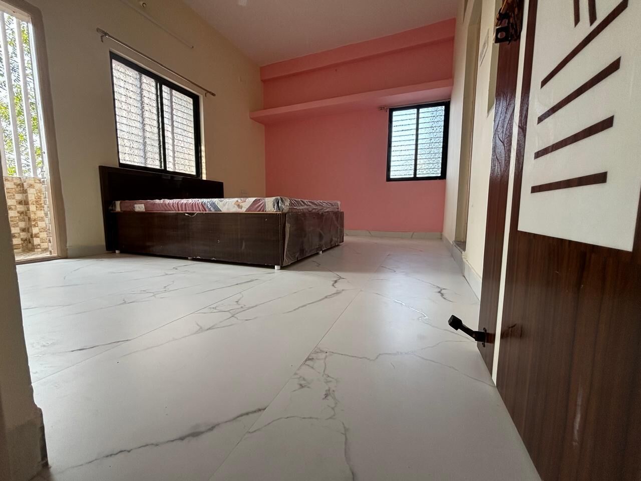 Una habitación con cama, armario, ventana y puerta.