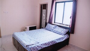 Un dormitorio con cama, ventana con cortinas y puerta.