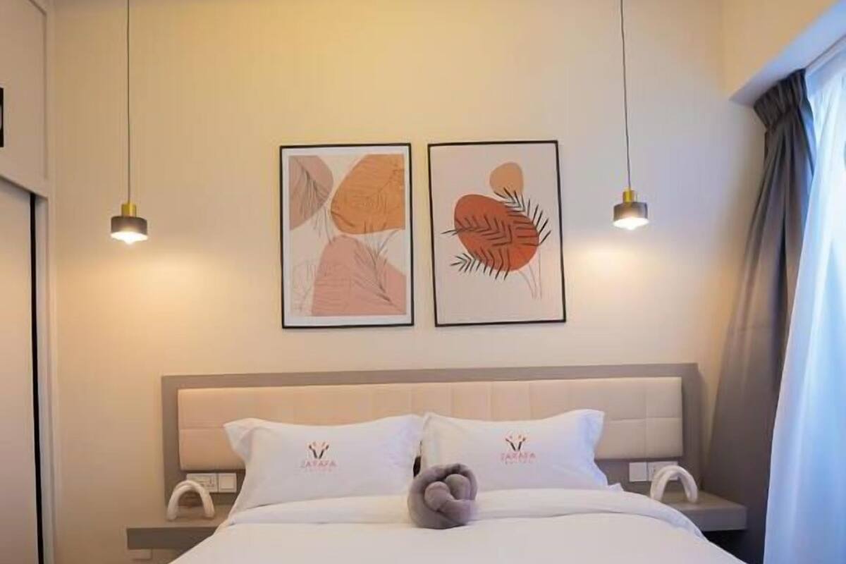 Ein Hotelzimmer mit einem Bett, zwei Nachttischen, einem Kopfteil und zwei wandmontierten Pendelleuchten.