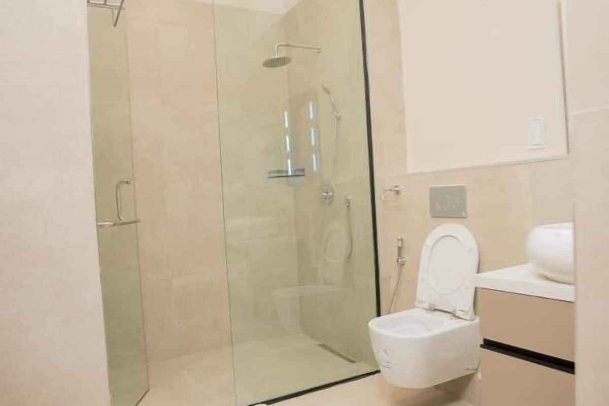 Ein modernes Badezimmer mit einer Duschkabine, einer Toilette und einem Waschbecken.