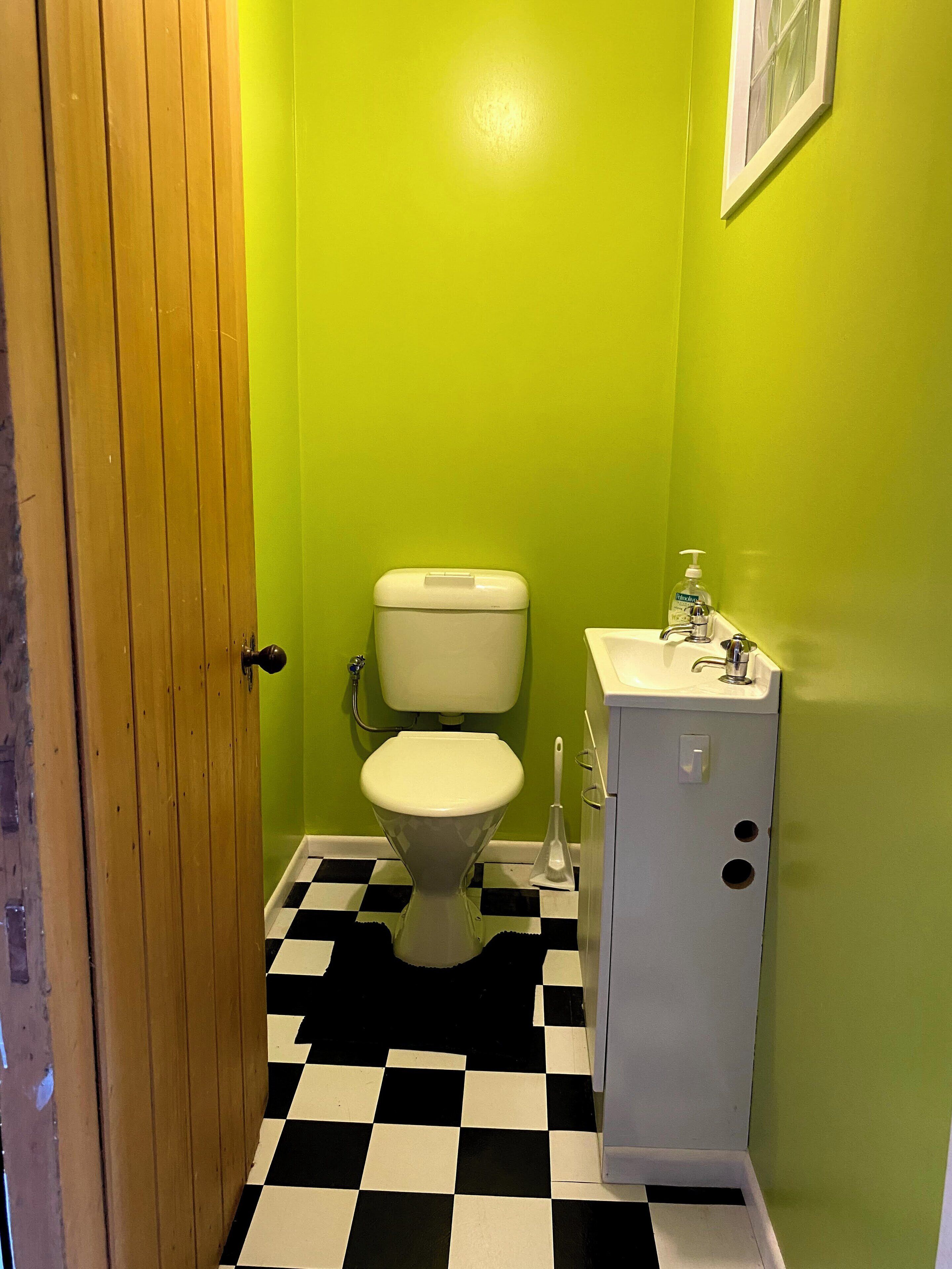 Ein Badezimmer mit Toilette, Waschbecken und einem Schachbrettboden.