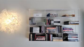 Una libreria con diversi libri e un cartello che indica Apple TV 4K.