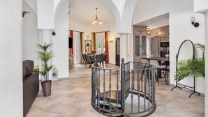 A spacious interior with a central spiral staircase, a dining area with chairs and a table, and a kitchen area with cabinets and appliances. - Villa, Private Pool, 5-Minute Walk to the Beach (La Herradura)