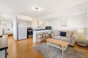 A modern apartment with a kitchen, living area, and dining space. - Ocean-View Studio | Full Kitchen + Laundry (Summerland)