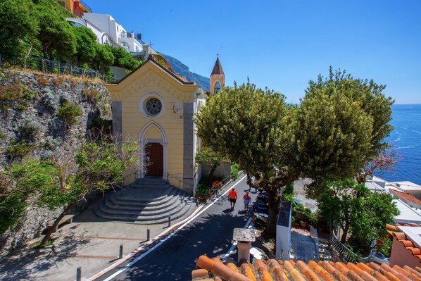 Eine Küstenkirche mit einem Glockenturm, Treppen, die zum Eingang führen, und Blick aufs Meer.