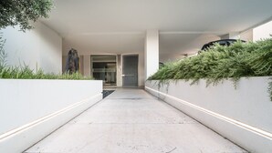 A modern, minimalist corridor with a concrete floor, white walls, and a glass door leading to a room labeled "TORRE BIANCA".