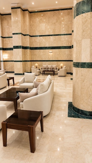 A lobby with marble flooring, a sofa set, and a coffee table. - Burj Mawaddah Hotel (Madinah)