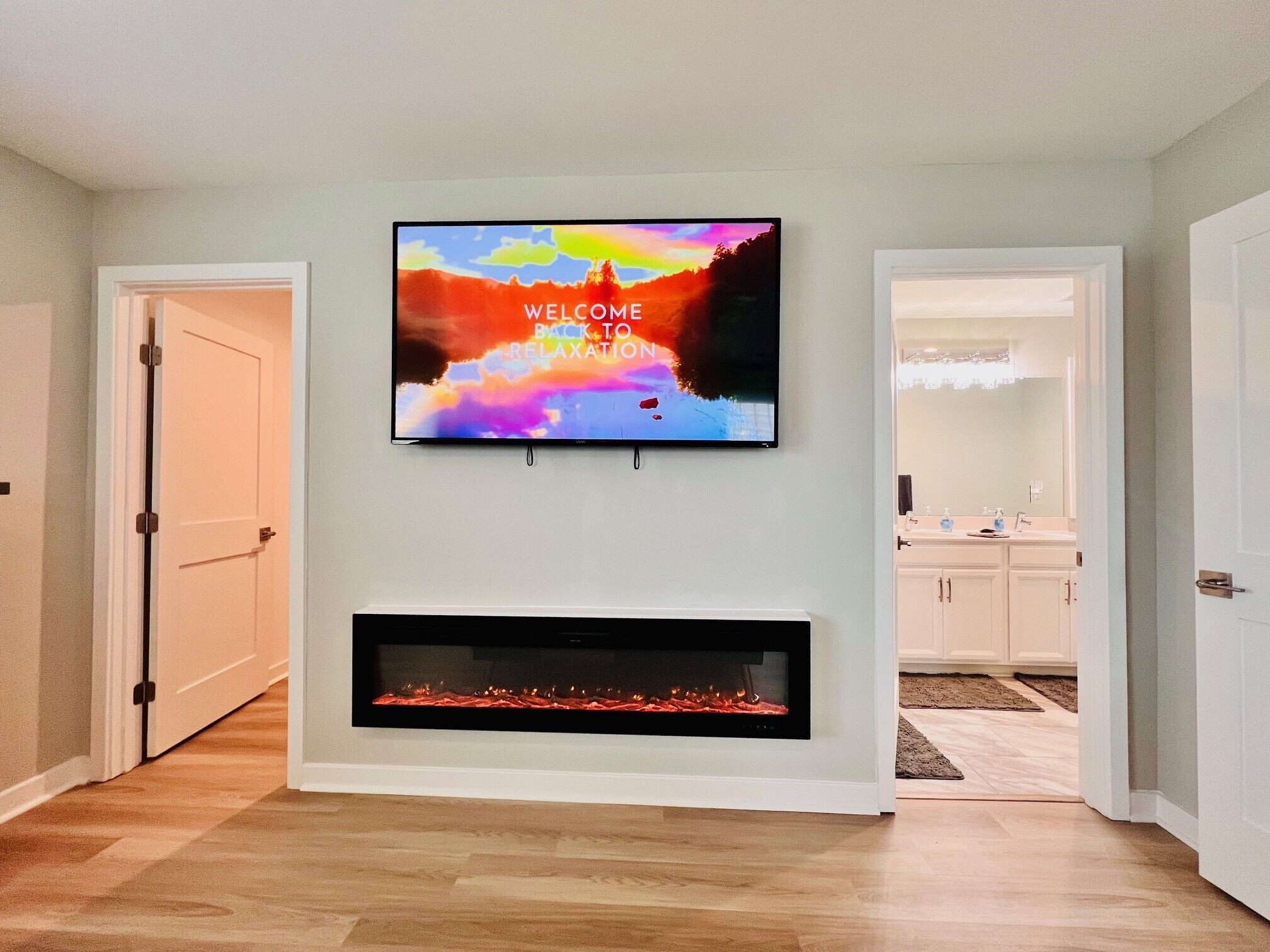 Ein Wohnzimmer mit Flachbildfernseher über einem Kamin.