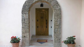 An entrance with a stone archway leading to a wooden door. There are two potted plants on either side of the entrance. - VILLA LA MASCOTTE PLUS IN CANNES (Cannes)