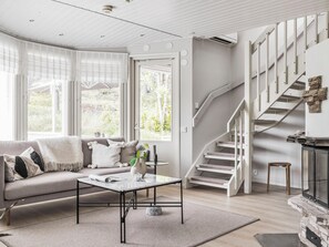 A modern living room with a sofa, coffee table, and a staircase.