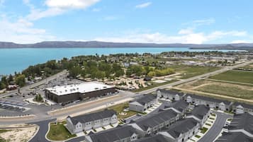 Un quartier résidentiel avec un grand bâtiment, probablement un centre communautaire ou une école, entouré de maisons et d’une route.