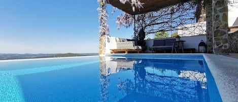 Una piscina al aire libre de temporada, sombrillas