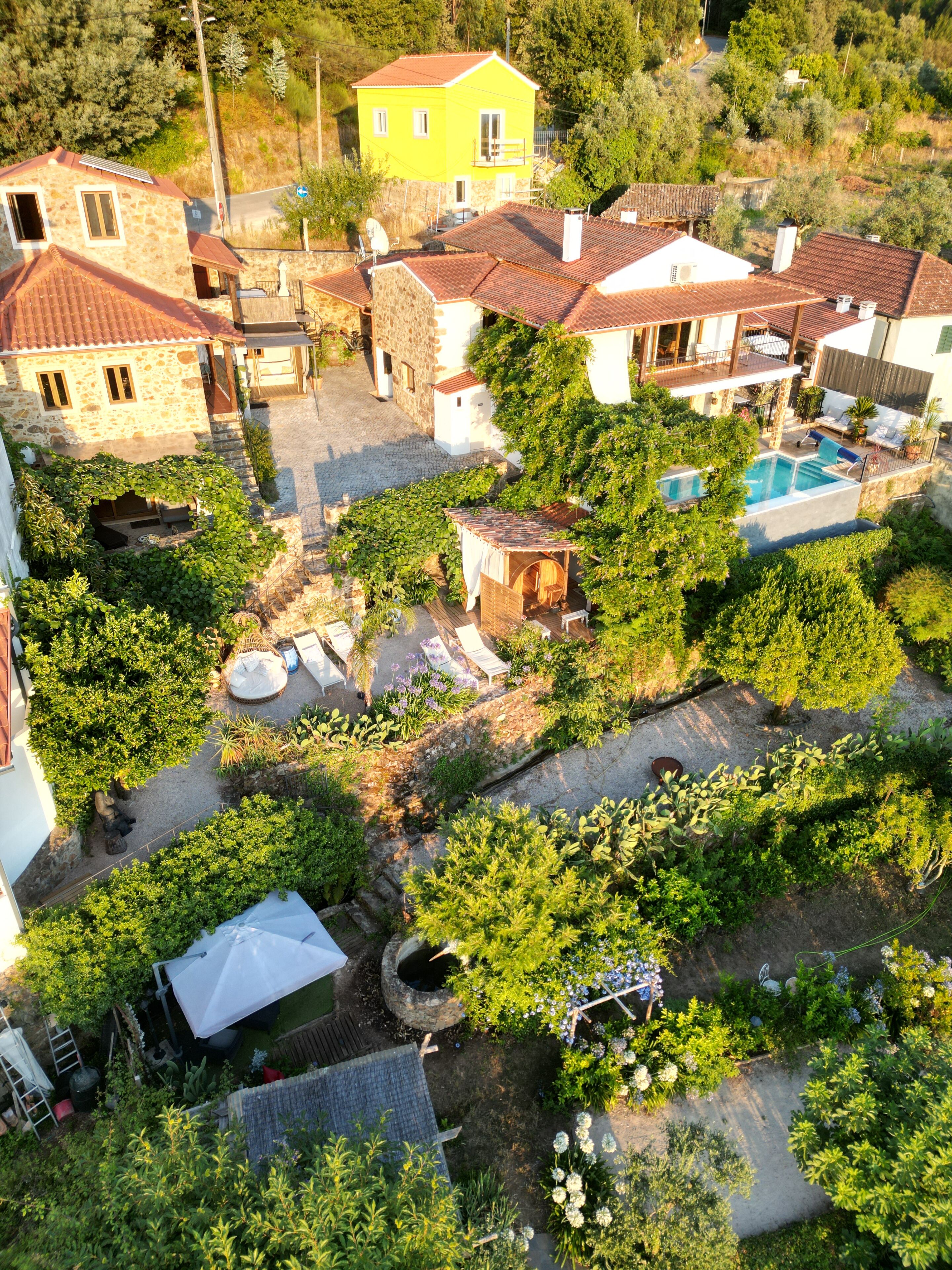 A residential area with stone houses, a swimming pool, and a garden.