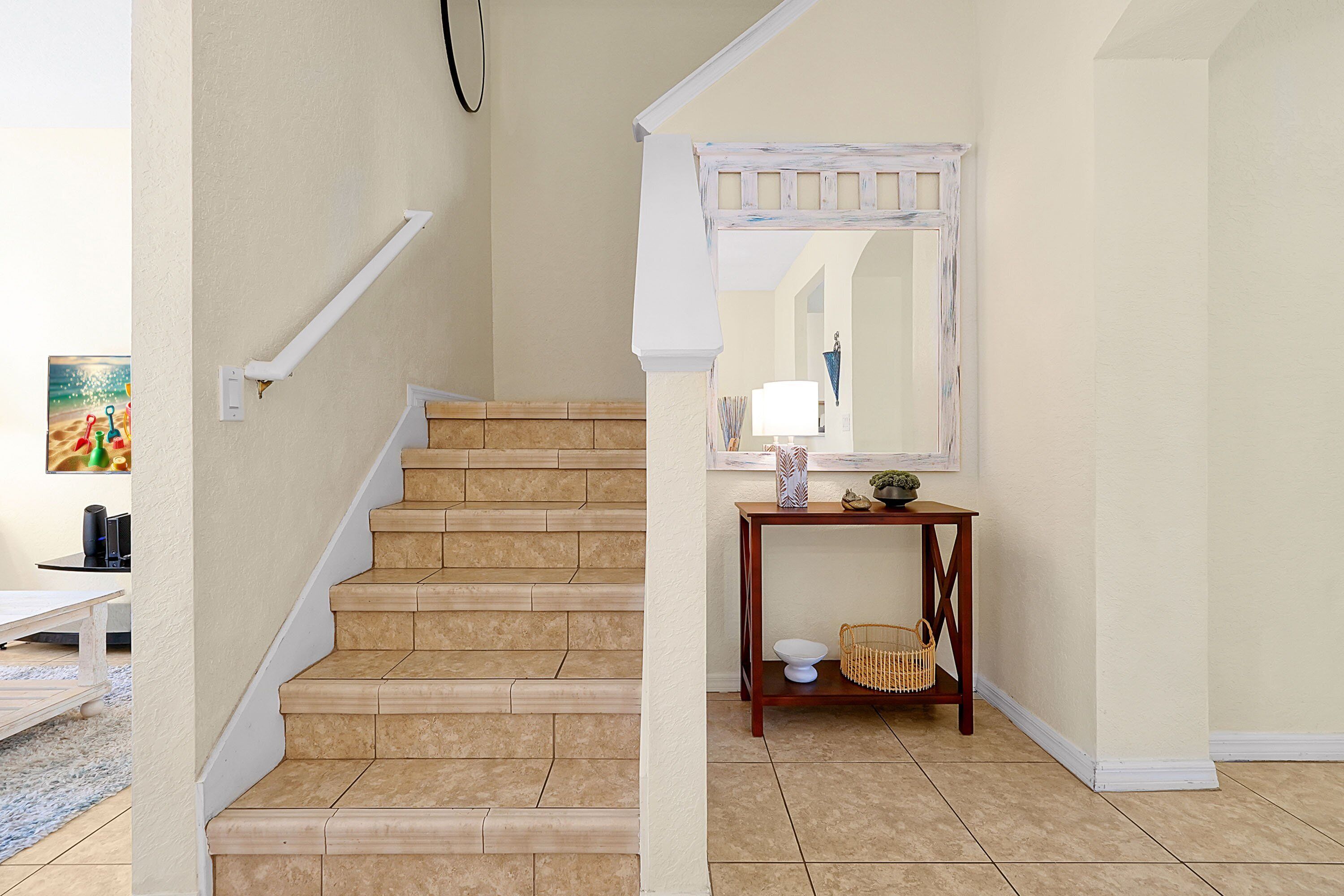 A staircase with beige tiles leading to a landing.