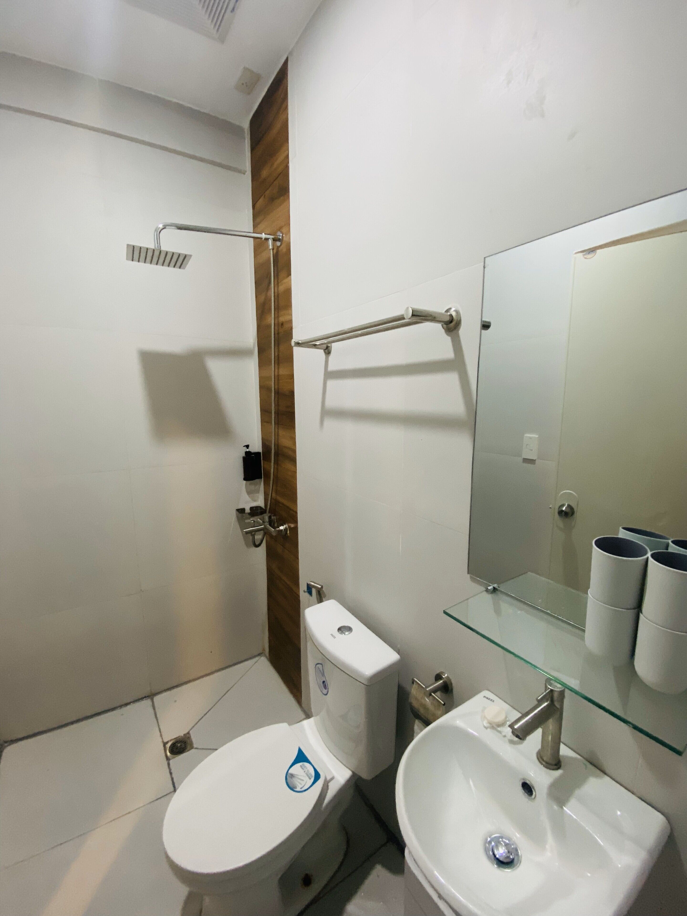 Un bagno moderno con toilette, lavabo e box doccia in vetro.