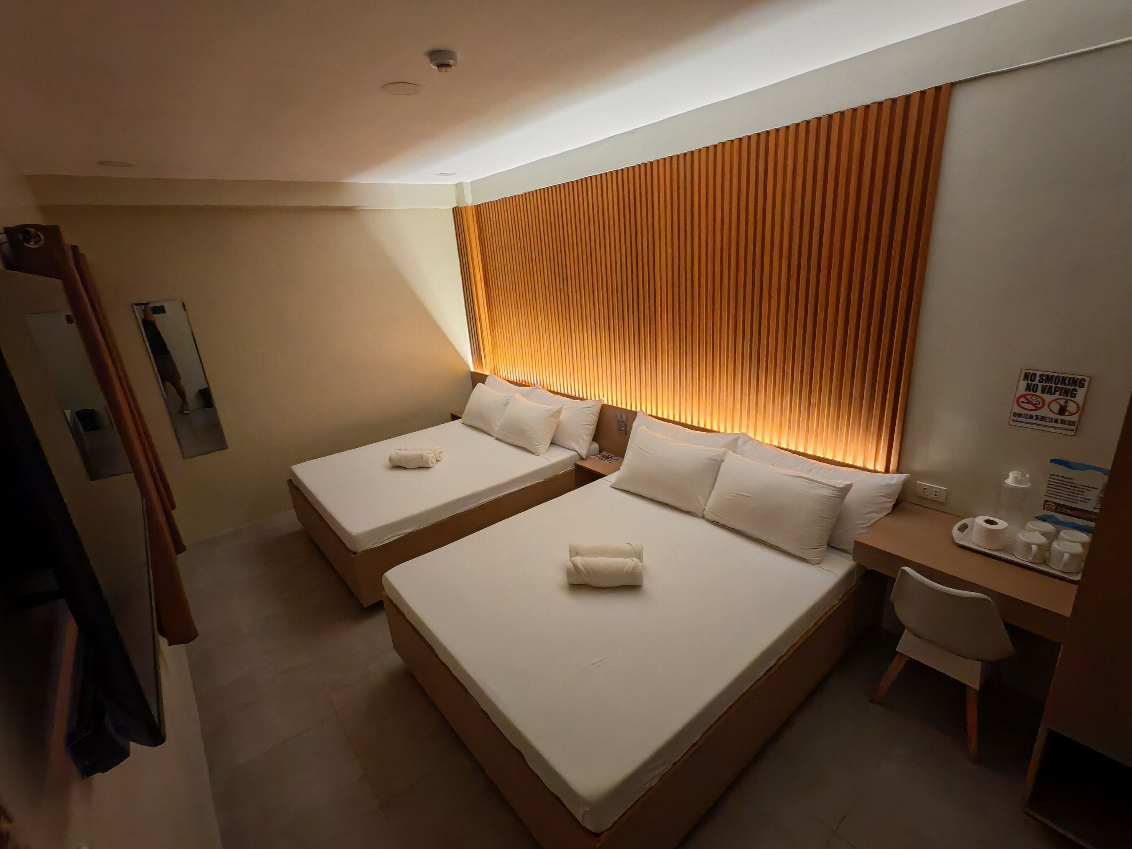 Ein Hotelzimmer mit zwei Betten, einem Schreibtisch und einem Stuhl.