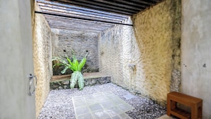 A narrow, enclosed space with a stone wall, a small wooden bench, and a potted plant. - Margossa Residence Kandy - Two Bedroom Design Villa (Kandy)