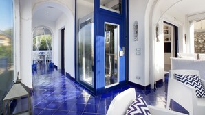A spacious hallway with a blue door, white walls, and a tiled floor. - Villa Blue Capri in Massa Lubrense (Massa Lubrense)
