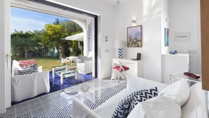 A modern bedroom with a large sliding glass door leading to an outdoor area with a pool and furniture. - Villa Blue Capri in Massa Lubrense (Massa Lubrense)
