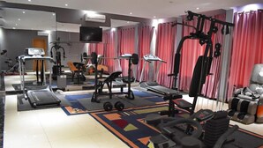 A gym with various exercise equipment, including treadmills, weight machines, and free weights. - Fams Embassy Suites (Badagry)