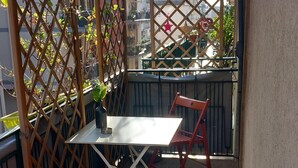 A balcony with a table and two chairs, a potted plant, and a decorative star. - A stone's throw from the center (Salerno)