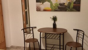 A room with a bed, two chairs, a small table, a painting of flowers, a mirror, and a TV on the wall. - A stone's throw from the center (Salerno)