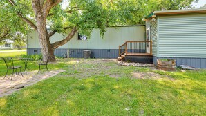 A backyard with a large tree, a small shed, and a patio area with metal chairs and a table. - 2 Mi to Sturgis Motorcycle Rally: Peaceful Home (Sturgis)