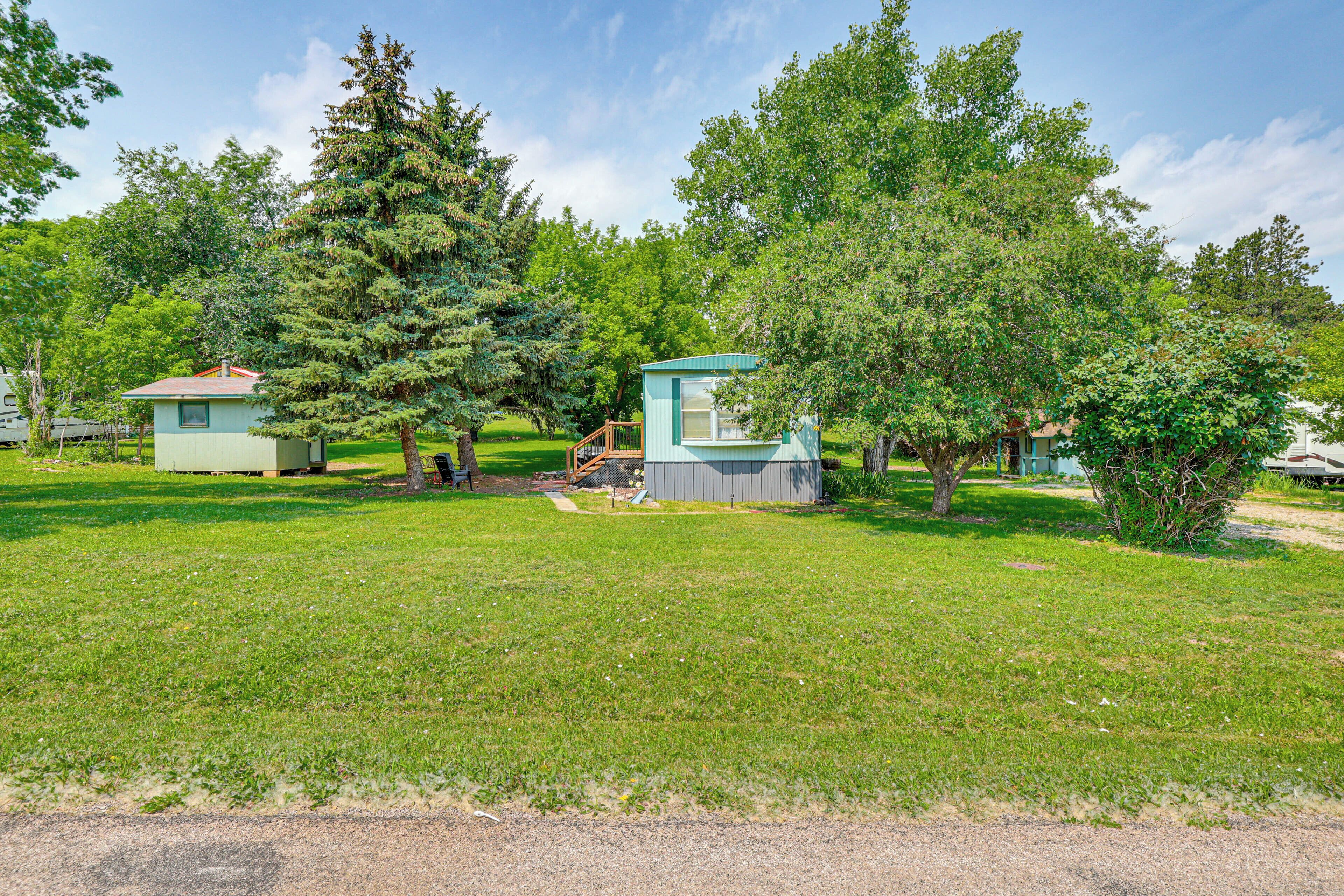 A campground with several small cabins surrounded by trees and grass.