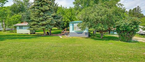A campground with several small cabins surrounded by trees and grass.