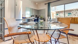 A modern kitchen with a glass dining table and wicker chairs. - Artsy Studio w/ Patio: 25 Mi to Santa Fe (Espanola)