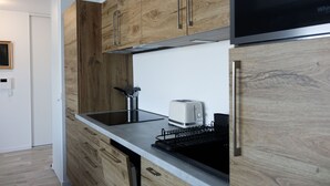 Una cocina moderna con armarios de madera, una campana extractora de acero inoxidable, un tostador y un lavavajillas.