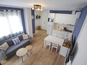 A modern apartment with a living area, kitchenette, and dining space.