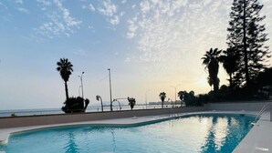 Una piscina con vista al océano y palmeras.