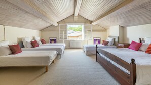A room with four beds arranged in a U-shape, a sloped ceiling, and a window providing a view of the outside. - Beautiful Stone House near Saint-Émilion and Libourne (Saint-Germain-de-la-Rivière)