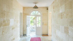 A hallway with stone walls, a red carpet, and a door leading outside. - Beautiful Stone House near Saint-Émilion and Libourne (Saint-Germain-de-la-Rivière)