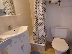 A bathroom with a white sink, a toilet, and a shower with a patterned curtain.