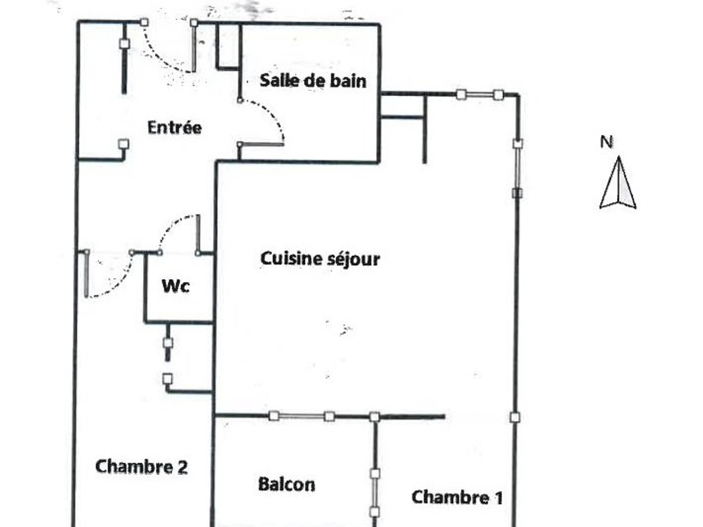 Ein Grundriss mit Toilette, einer Küche, einem Balkon und zwei Schlafzimmern.