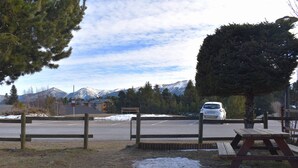 A parking area with a picnic table and a car. - Cozy 2-room apartment with garden in Bolquère (Bolquère-Pyrénées 2000)