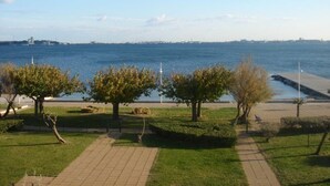 A park with a paved walkway, trees, and a view of the sea. - Comfortable Studio with Loggia in Balaruc-les-Bains (Balaruc-les-Bains)
