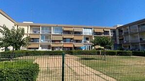A multi-story apartment building with balconies and a fenced courtyard. - Comfortable Studio with Loggia in Balaruc-les-Bains (Balaruc-les-Bains)