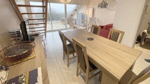 Une cuisine moderne avec une table à manger en bois, des chaises et une échelle.