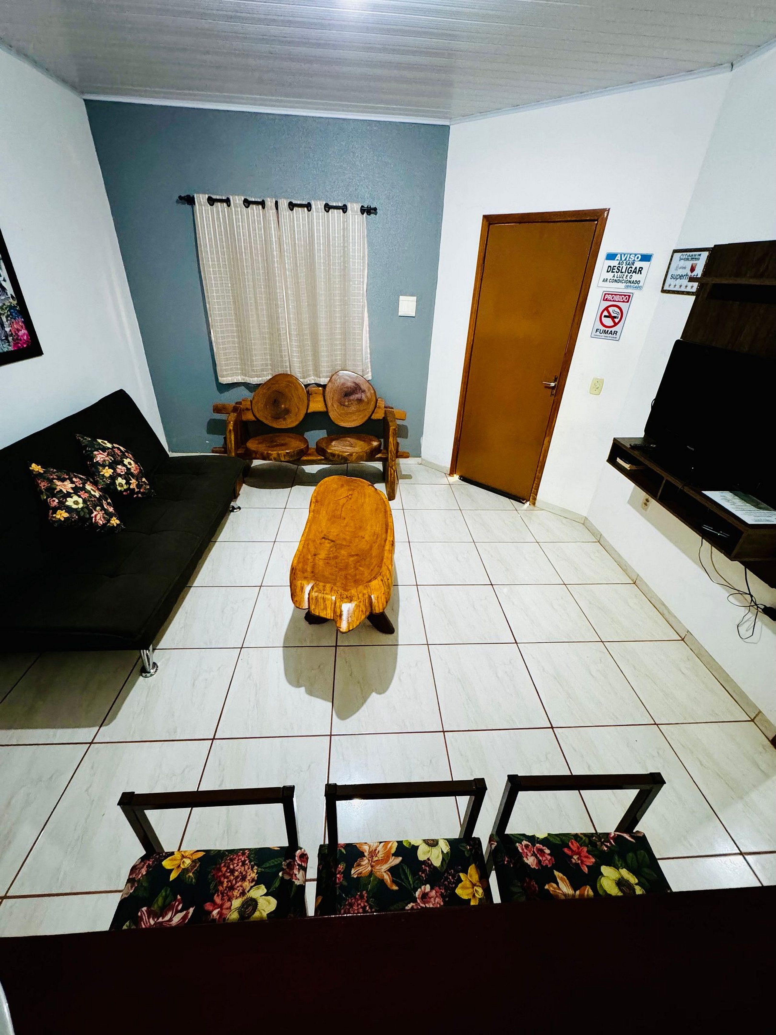 A living room with a sofa, a wooden bench, a small table, and a television.