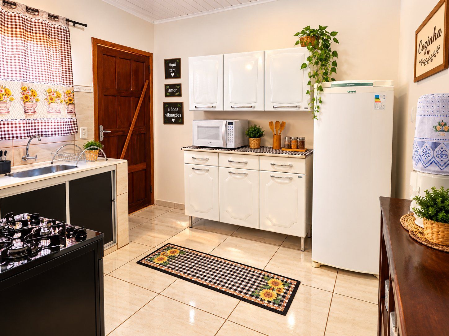 A kitchen with white cabinets, a microwave, a refrigerator, and a sink.